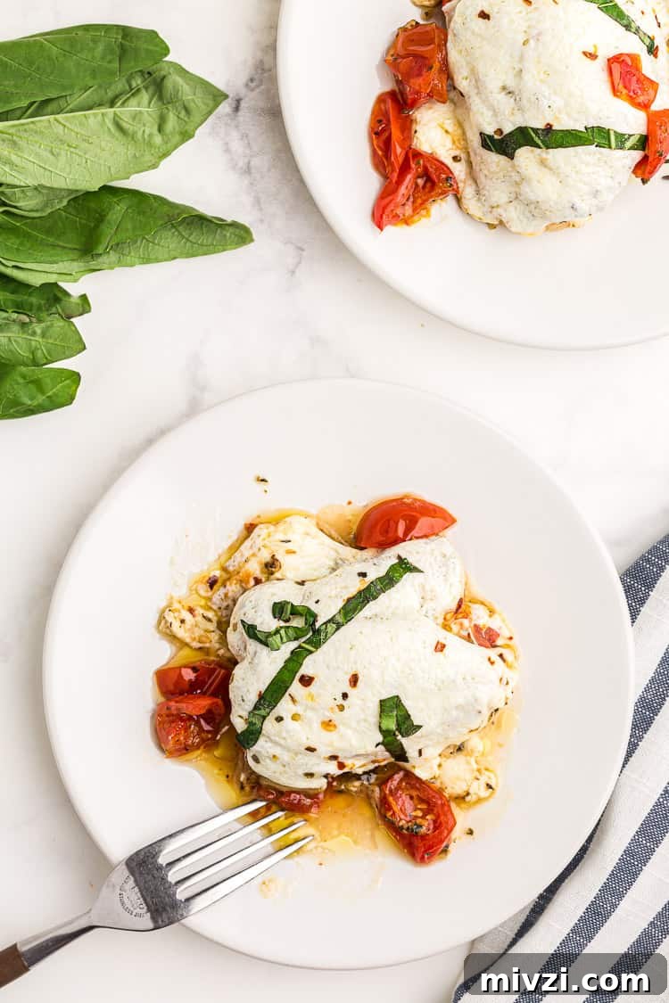 overhead view of a single keto chicken thigh covered with mozzarella on a white plate