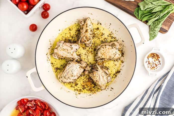 raw keto chicken thighs in a pan covered in olive oil and spices