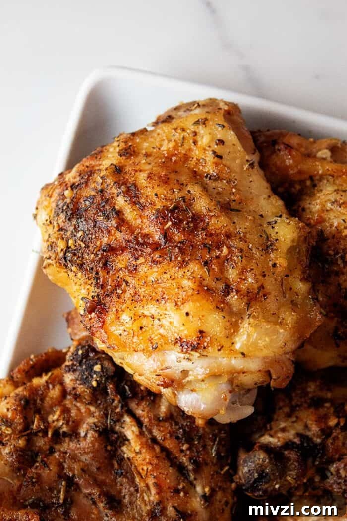 overhead view of ready to serve crispy air fryer garlic parmesan chicken thighs on a white plate