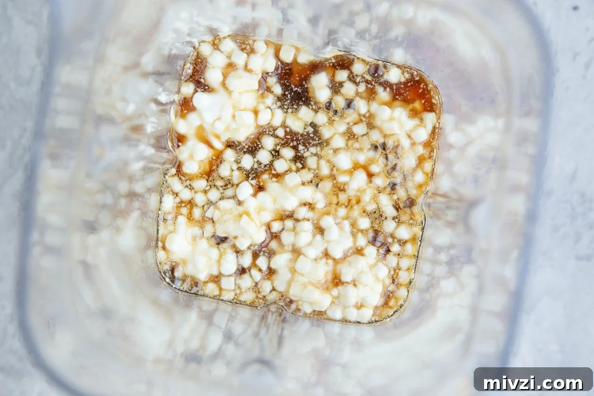 Cottage cheese, pure maple syrup, and almond butter in a blender, to be blended for brownies.