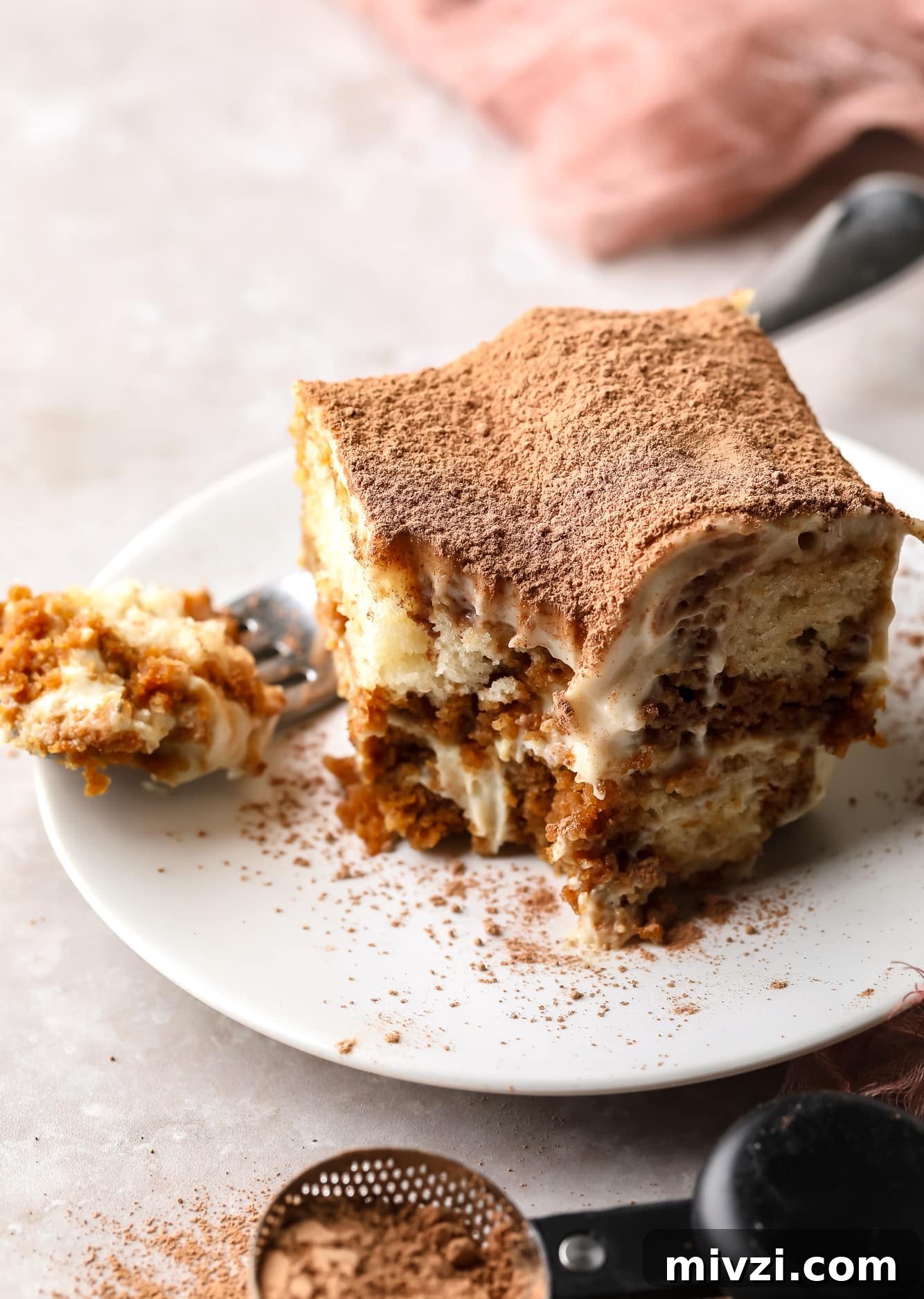 a slice of vegan tiramisu on a white plate.