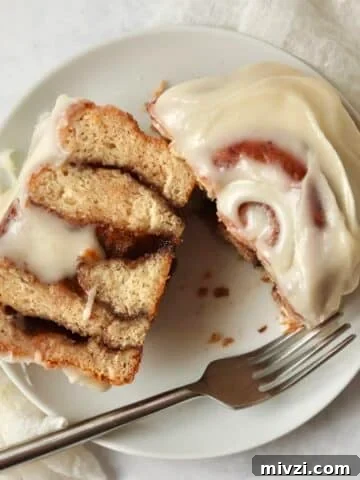 Single serve cinnamon roll with icing on a plate.