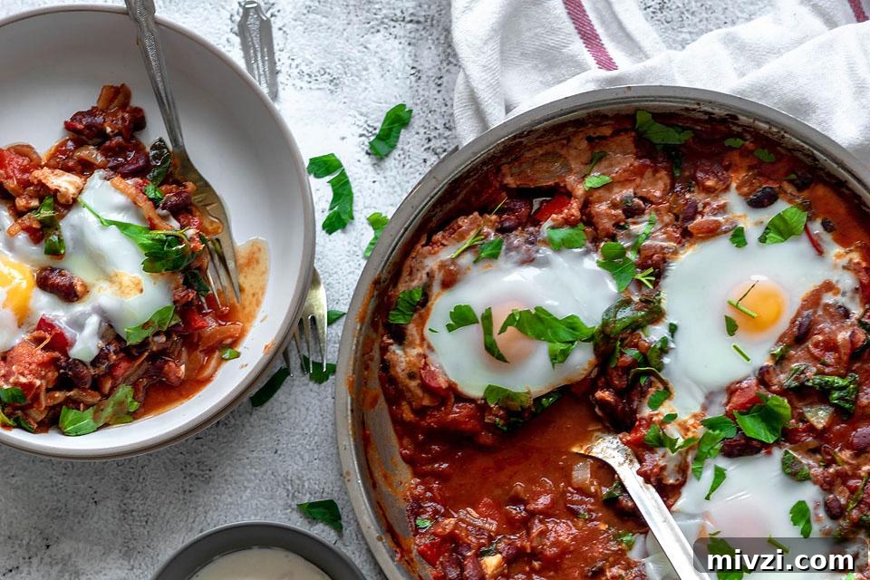 29 Cozy One-Pot Fall Dinners That Cut the Cleanup 16 Shakshuka with eggs on top in a pan being cooked.