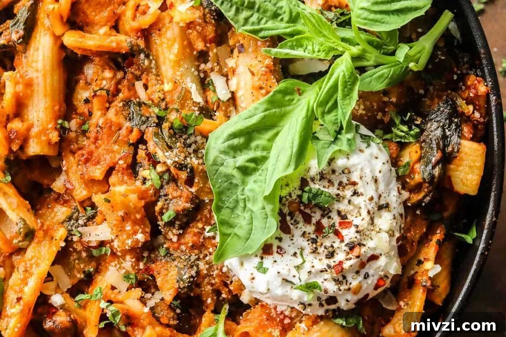 29 Cozy One-Pot Fall Dinners That Cut the Cleanup 18 Pasta with mushrooms, spinach and tomatoes in a pot with cheese on top.