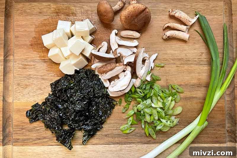 Horizontal image of prepped fresh ingredients on a wooden cutting board.